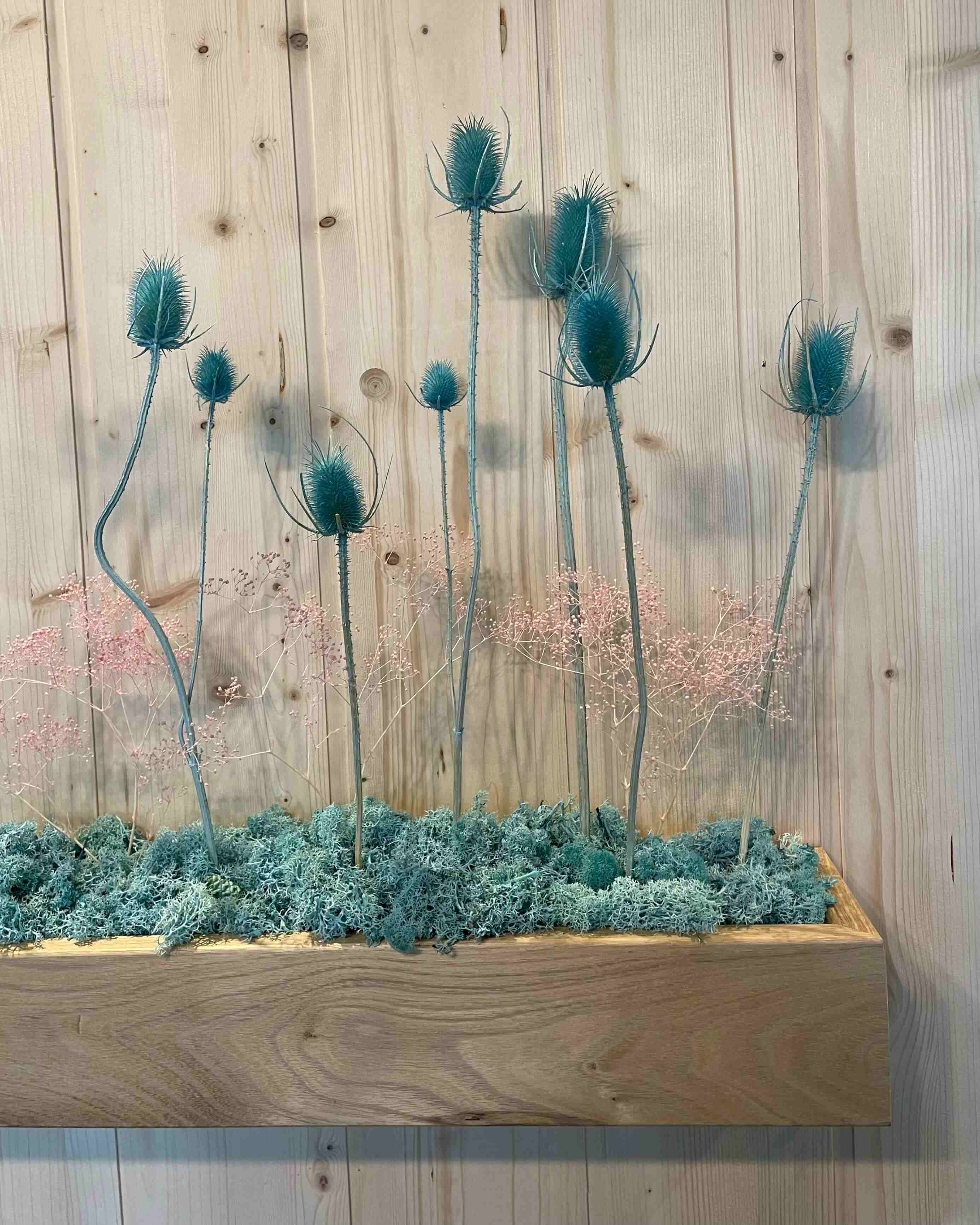Stand salon Serbotel octobre 2023. Décoration design en plantes naturelles stabilisées. Composition sur les tons bleu turquoise et rose.