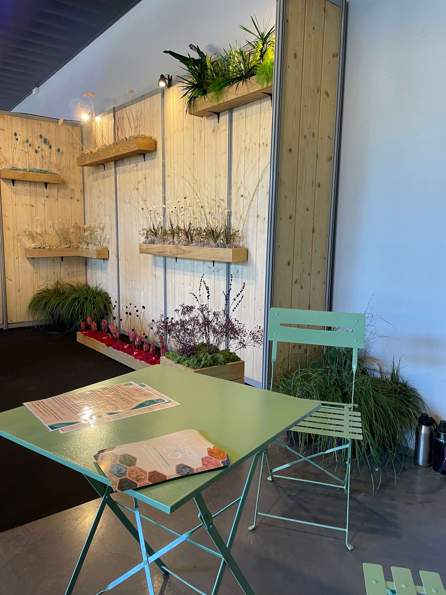 Stand salon Serbotel octobre 2023. Décoration design en plantes naturelles stabilisées. Stand exposant au salon avec table et chaises.