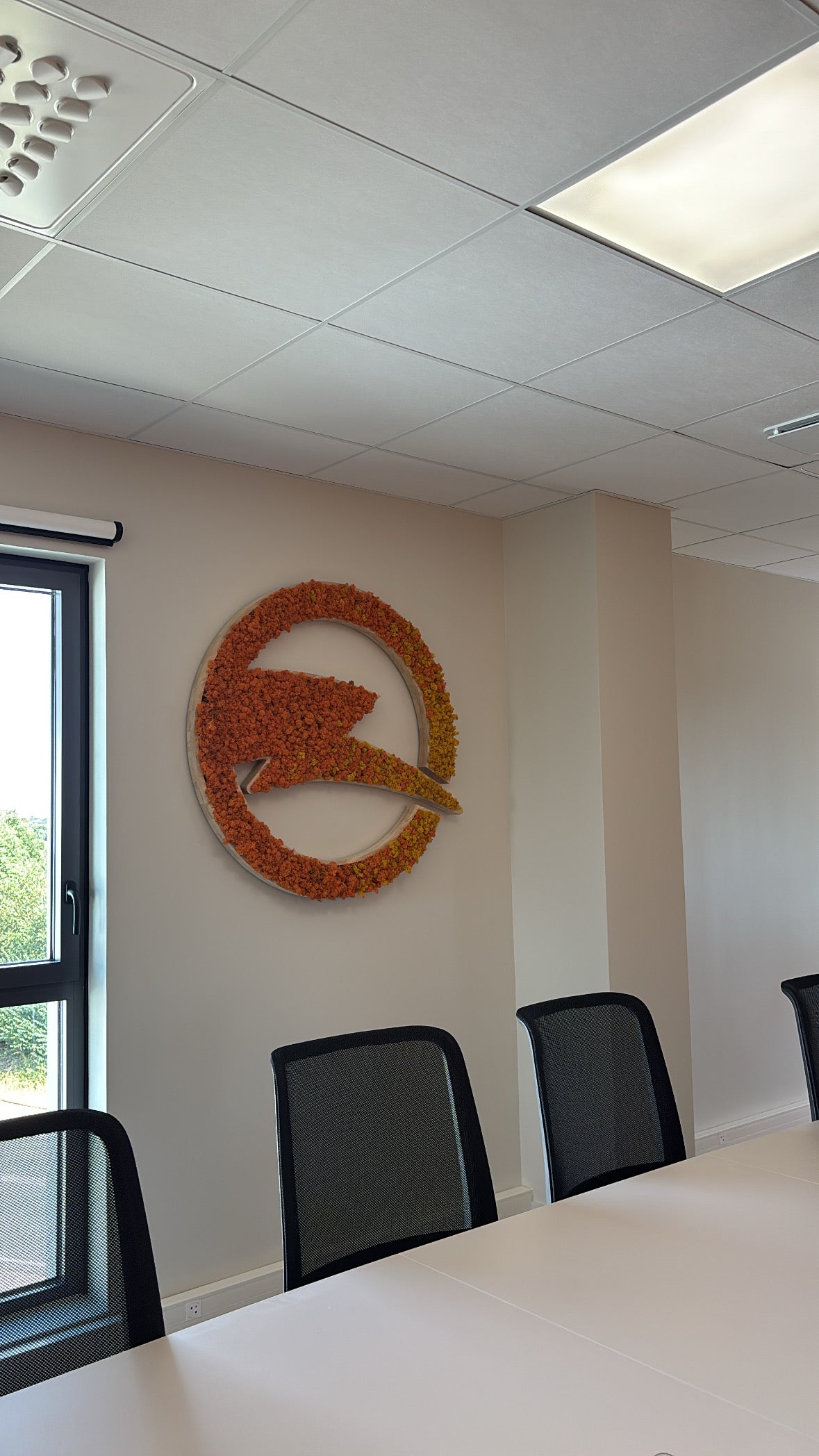 Logo végétal Energies de Loire en lichen stabilisé orange dans une salle de réunion des bureaux de Guérande