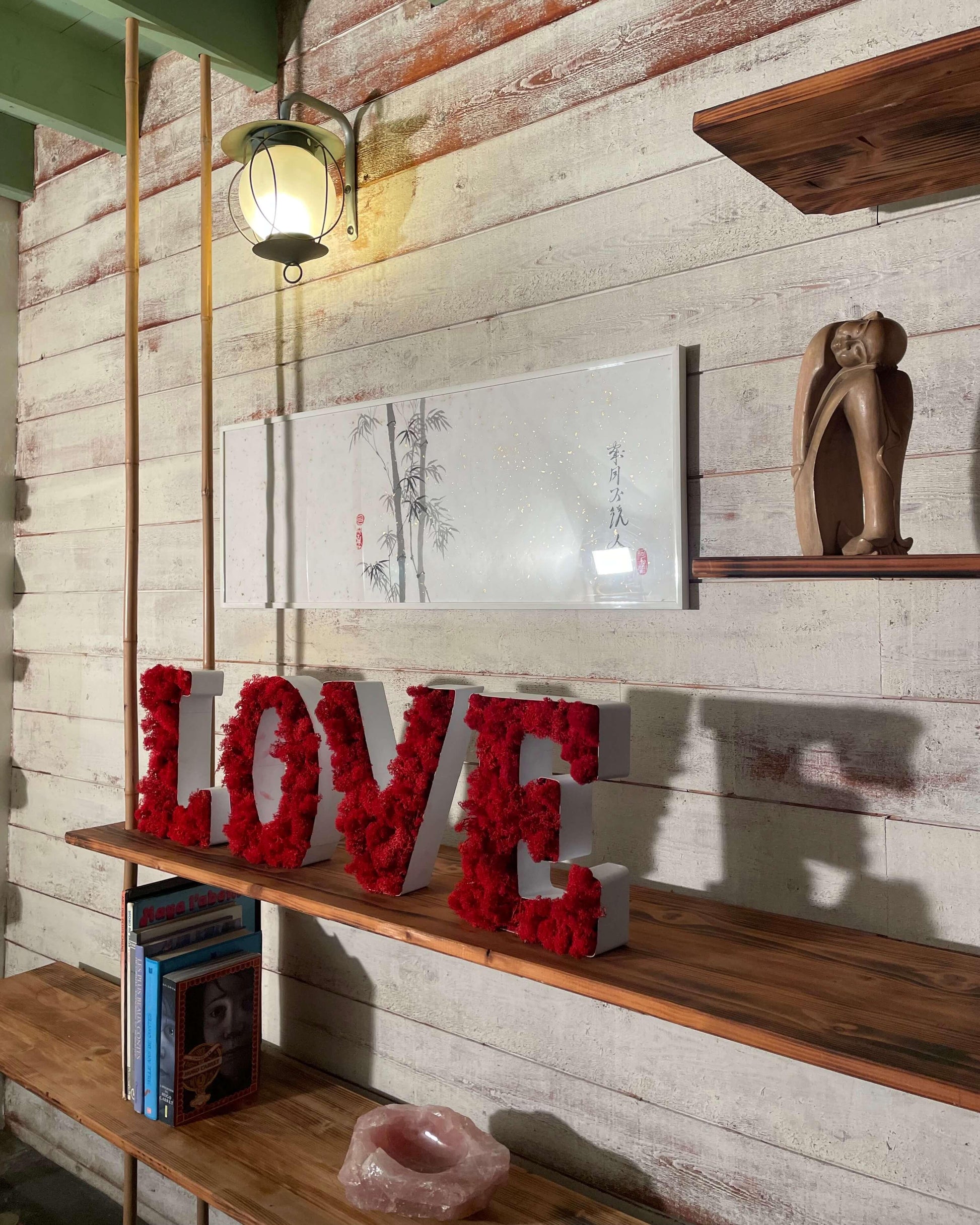 Lettres en métal pour déco LOVE avec du lichen stabilisé rouge, posé sur une étagère en bois massif dans une chambre moderne.